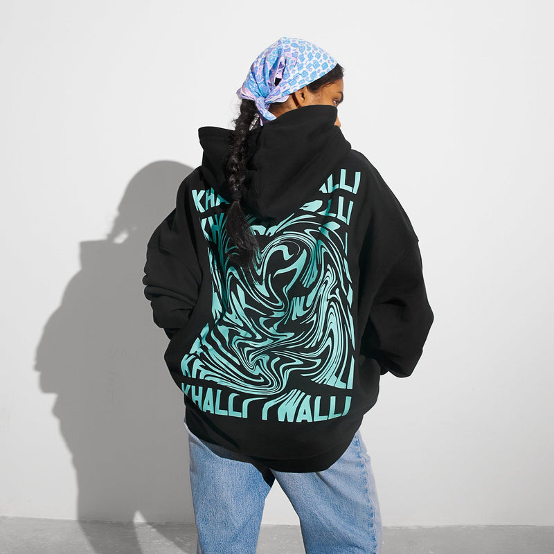 Khalli Yiwalli hoodie in black with neon mint Arabic print, worn front view