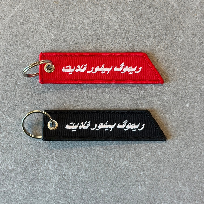 Remove Before Flight Arabic keychain by Elbotik